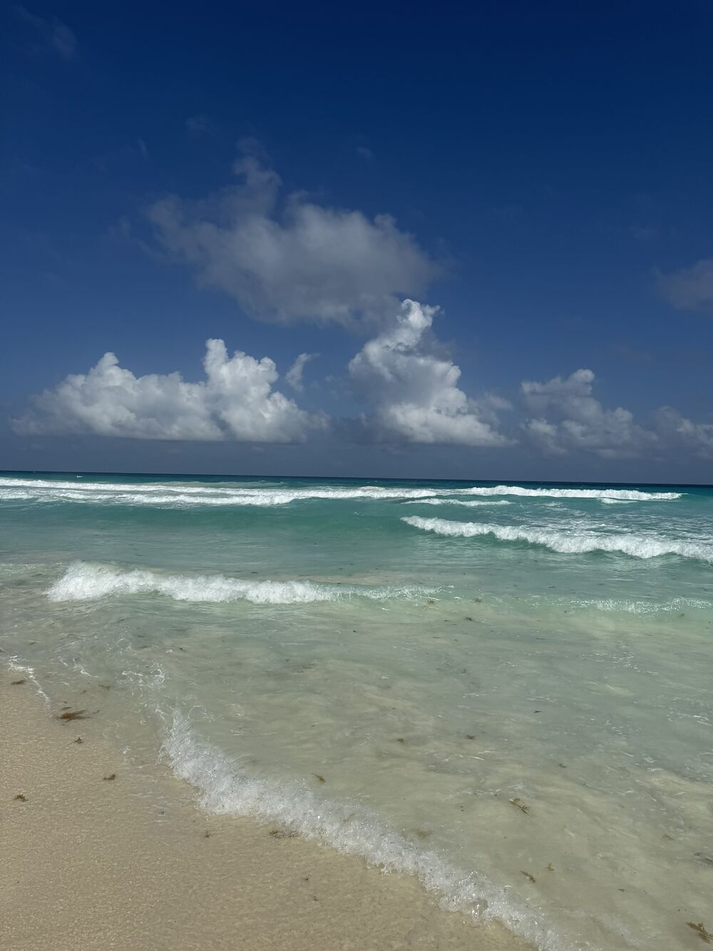 Turquoise surf rolling onto a white sand beach